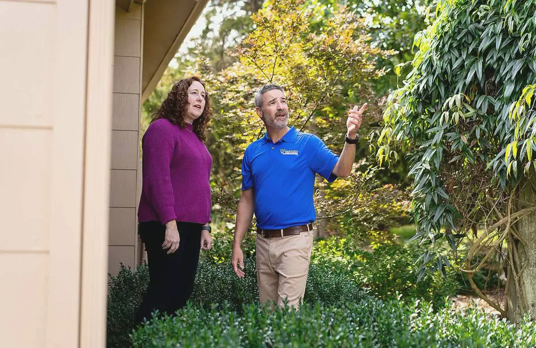 A Bartlett arborist pointing out trees to a homeowner